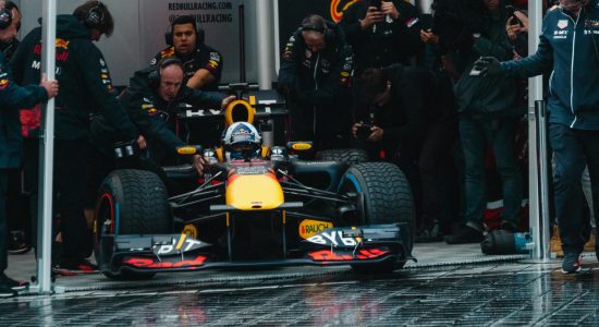 Exciting Formula One car during a dynamic pit stop, showcasing teamwork and precision.